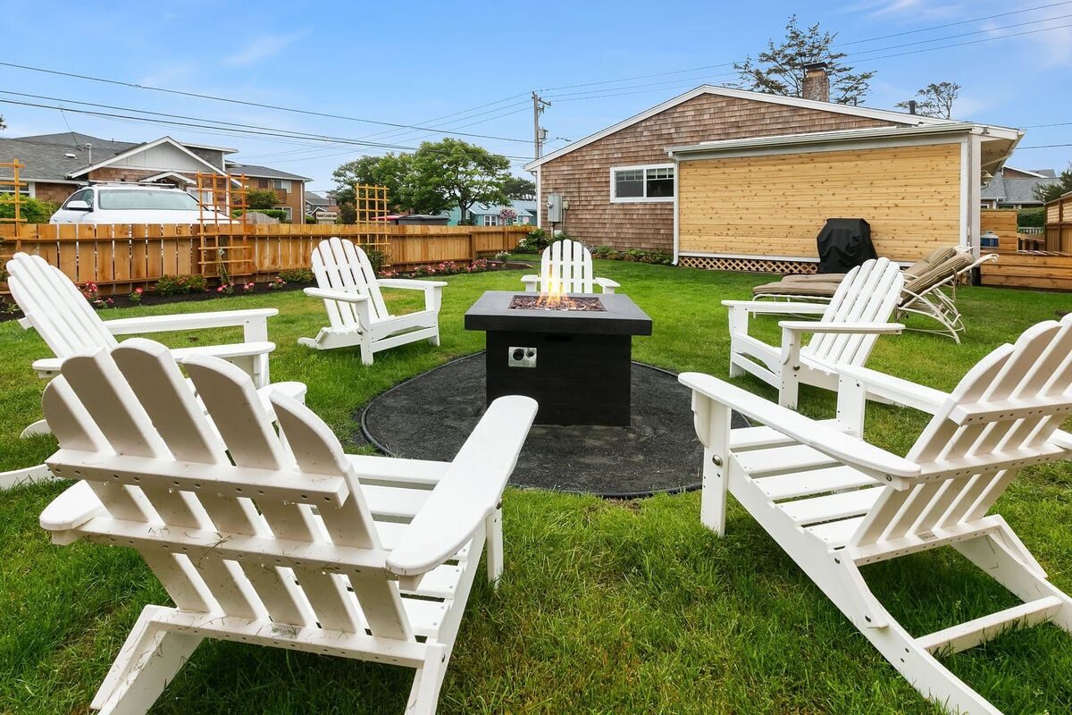 Fenced backyard with fire pit and Adirondack chairs